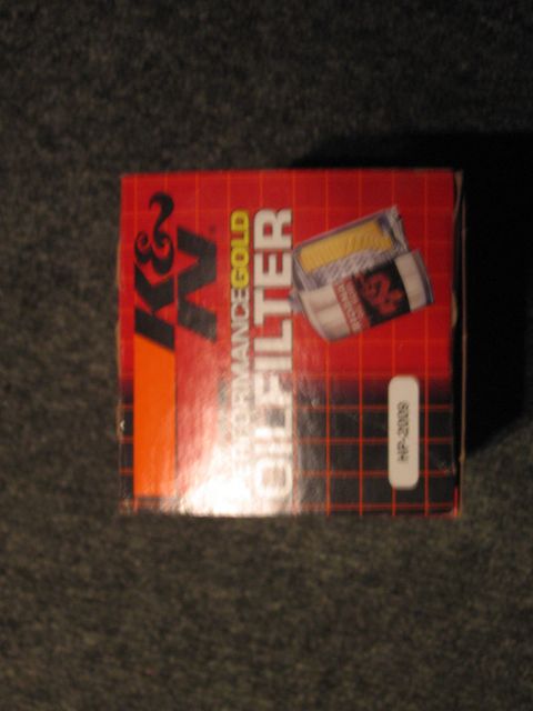 1995 Ford Thunderbird - Box for a K&N Performance Gold Oil Filter, part number HP-2009, is shown on a dark surface.