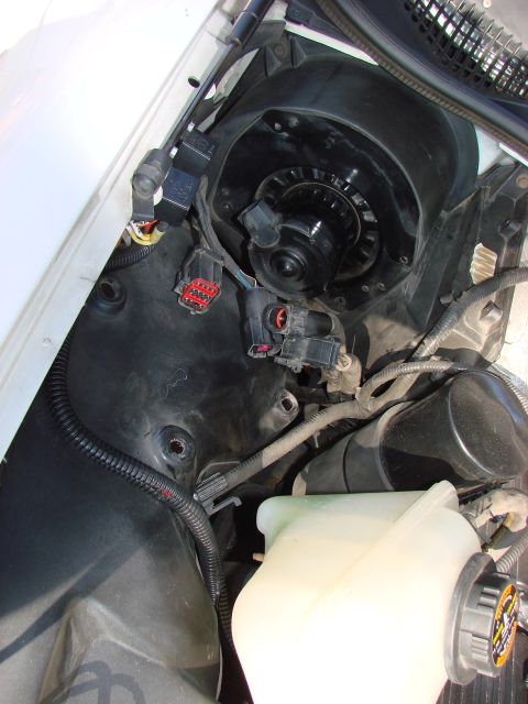 1997 Mercury Grand Marquis - The Coolant bottle removed (3 -11mm nuts inside the fender liner), wiring on blower fan disconnected and getting ready to remove the blower…