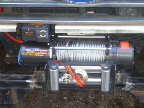 1989 Ford Bronco - Winch assembly with PE8000 label attached to the front of a vehicle.