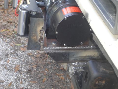 1989 Ford Bronco - Close-up of a winch and its custom mounting hardware on a vehicle.