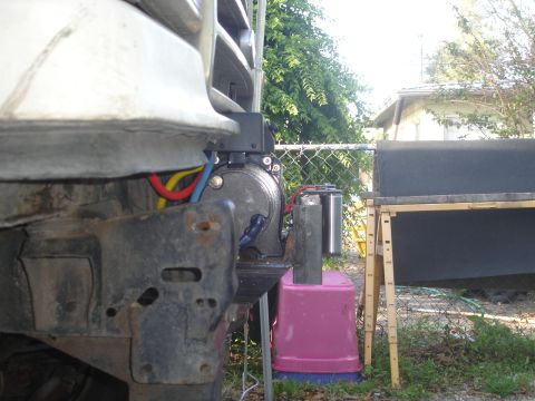 1989 Ford Bronco - Close-up view of a winch mount and its wiring, attached to the front of an unidentified vehicle.