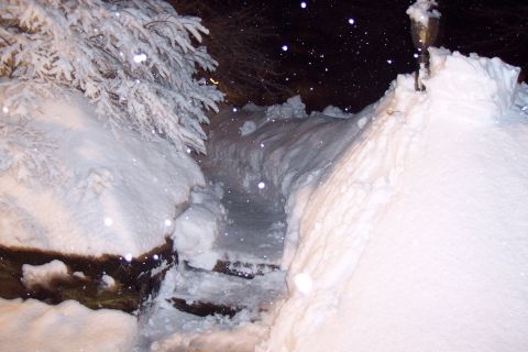 2001 Ford Crown Victoria - Outdoor steps and walkway buried under heavy snowfall at night.