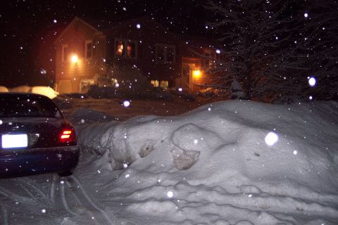 2001 Ford Crown Victoria - A dark blue 2001 Ford Crown Victoria is parked on a snow-covered road at night, with snow falling.