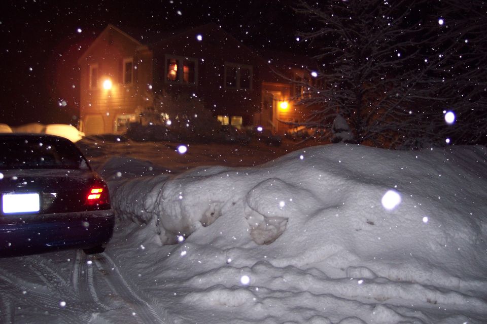 Rear view of a dark blue 2001 Ford Crown Victoria parked in heavy snow at night