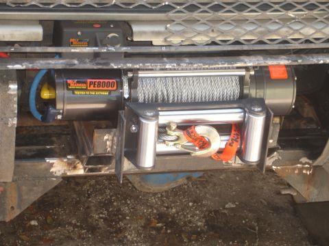 1989 Ford Bronco - Close-up of a winch and its hook, mounted on a vehicle's front end.