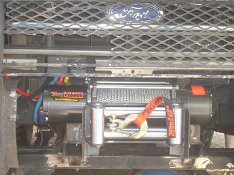 1989 Ford Bronco - Close-up of a winch mounted to the front of a vehicle with a Ford emblem visible.