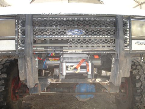 1989 Ford Bronco - This truck features a winch mounted below the grille, with a Ford emblem and 4x4 badging visible.