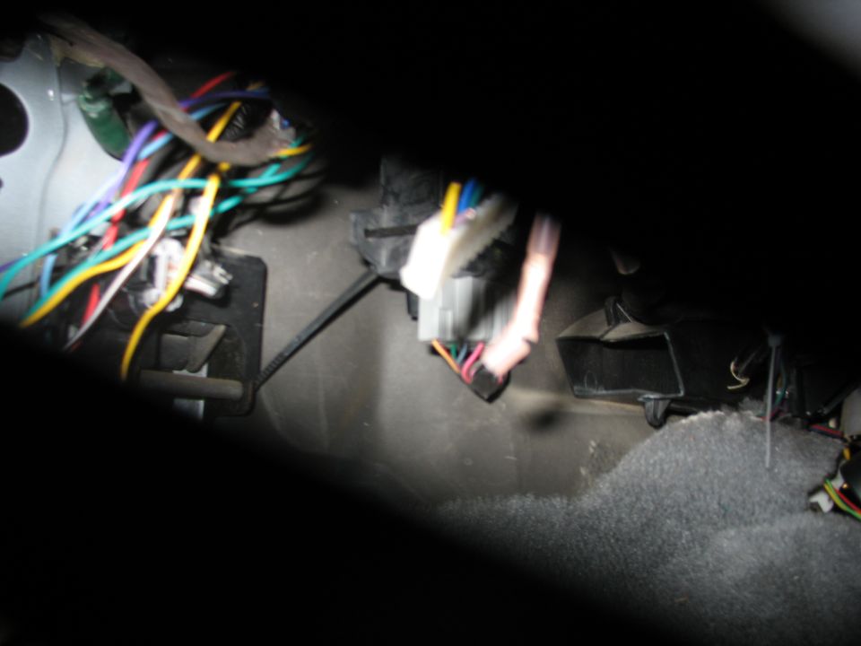 Vehicle interior with a bundle of colorful wires connected to a black electrical connector