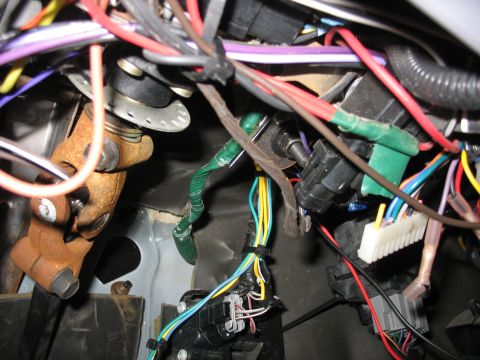 1995 Ford C-350 (Centurion Conversions) - A complex network of wires and connectors is visible within the steering column area of a vehicle.