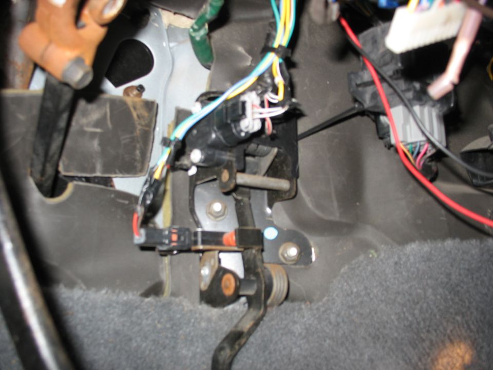 Close-up of brake pedal assembly with wiring harness and connectors