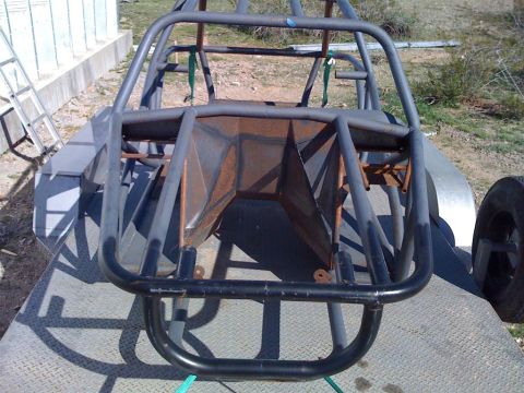 1994 Ford Bronco - This custom buggy frame is on a trailer, viewed from the front. The metal tubing is gray and appears to be unfinished.