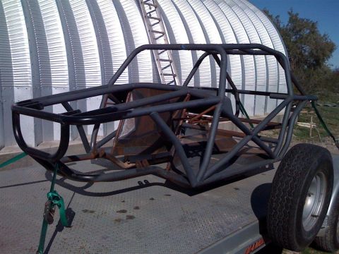 1994 Ford Bronco - This image shows the bare frame of an off-road buggy, likely undergoing construction or repair, secured to a trailer.