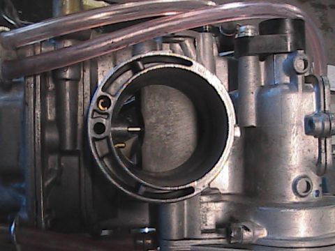 2007 Yamaha YZ450F - Close-up view of a motorcycle carburetor intake, showing internal components and fuel lines.