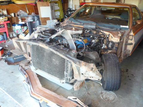 1975 Ford Ranchero - Disassembled 1972 Ford Ranchero in a garage, with the front end removed to expose the engine and radiator.