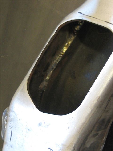 1996 Ford Bronco - This image shows a close-up view of a metal part with a welded seam visible through an opening.