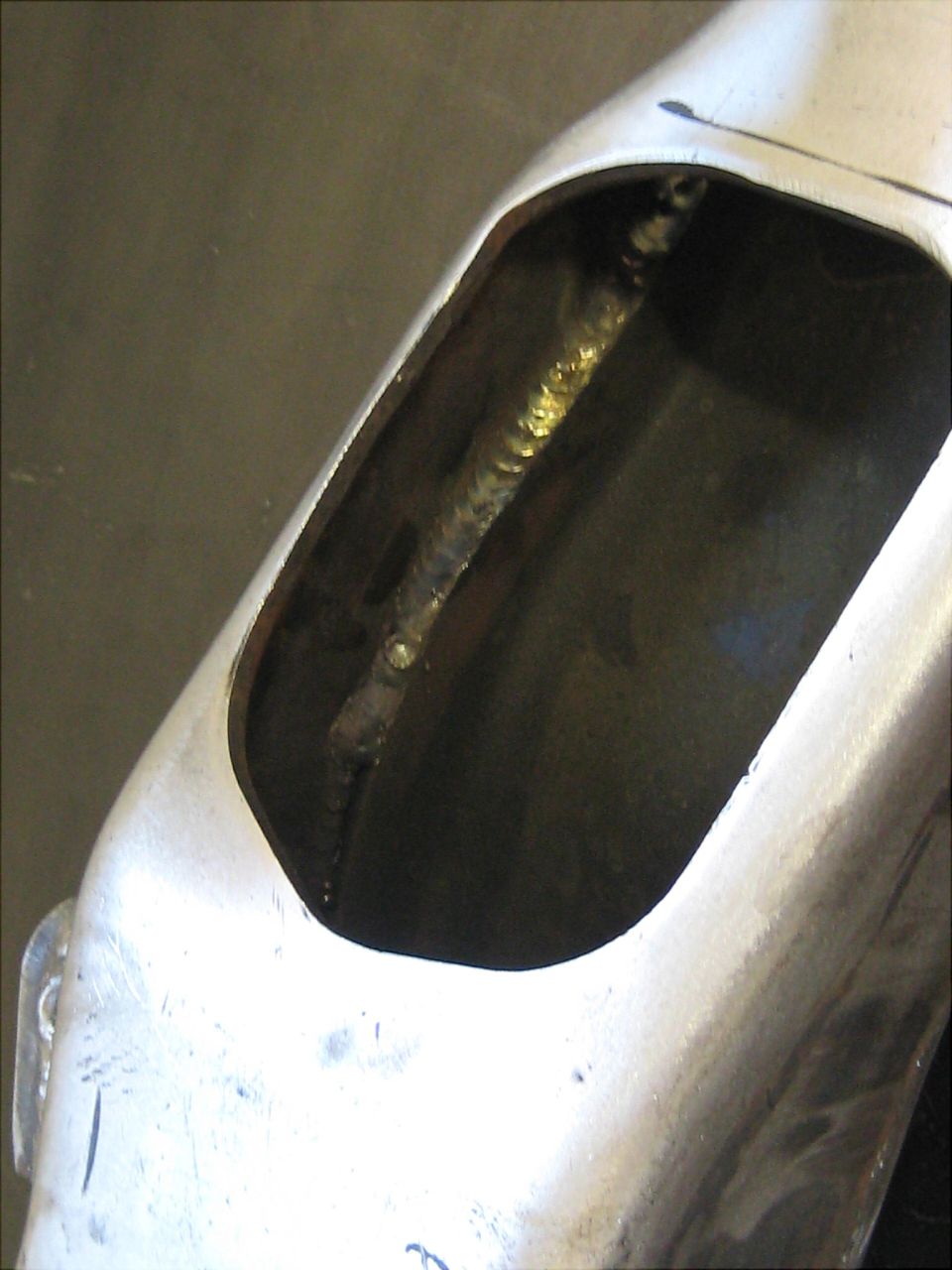 Close-up of a metal component with visible welding inside an opening