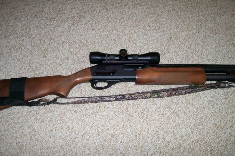 1993 Ford Bronco - A shotgun with a scope is shown on a carpeted surface.