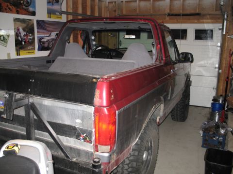 1995 Ford Bronco - Rear view of a 1995 Ford Bronco, modified with a custom bed, inside a garage.