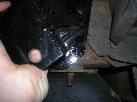 1993 Ford Bronco - Close-up of a vehicle frame component being held by a hand.