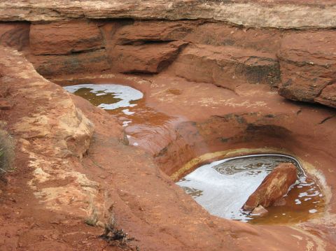 1983 Jeep CJ7 - Natural rock pools with water and foam, set in red sandstone formations. Supermotors.net logo visible.