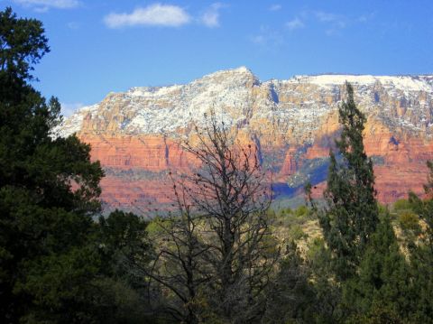 1983 Jeep CJ7 - A scenic view of Sedona's red rock mountains, dusted with snow under a clear blue sky.