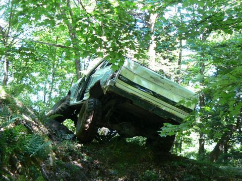 1995 Ford Bronco - This 1995 Ford Bronco is shown navigating a challenging off-road trail through a dense forest.