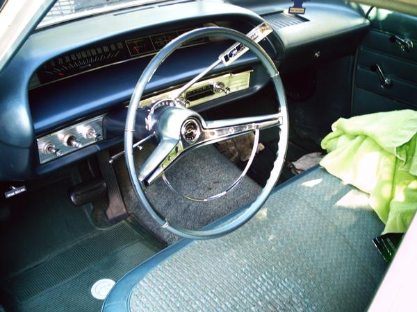 Interior view of a vintage car, showing the dashboard, steering wheel, and seats