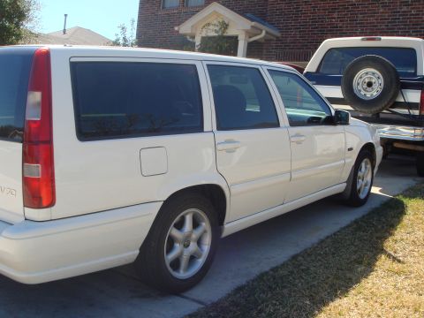 1998 Volvo V70 - Side view of a white 1998 Volvo V70 wagon and a blue pickup truck.