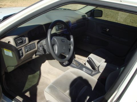 1998 Volvo V70 - The interior of a 1998 Volvo V70 features a tan dashboard, gray steering wheel, and cloth seats.