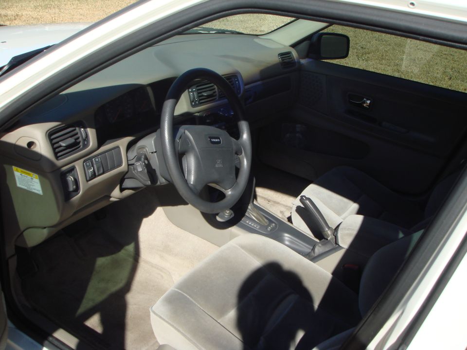 Beige interior of a Volvo showing steering wheel, dash and automatic shifter