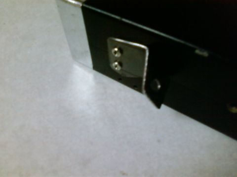 1995 Ford Bronco - Close-up of a black ashtray CB mount with chrome trim and a metal bracket attached.