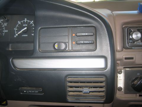 1995 Ford Bronco - Interior dash close-up showing the tachometer and speedometer at left, an amber-lit switch panel with "4X4" and "LOW RANGE" indicator light…