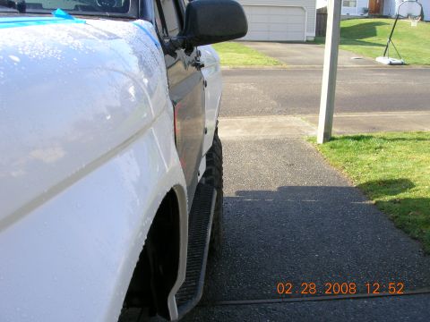 1996 Ford Bronco - Side profile of a 1996 Ford Bronco, wet with water droplets on the exterior paintwork.