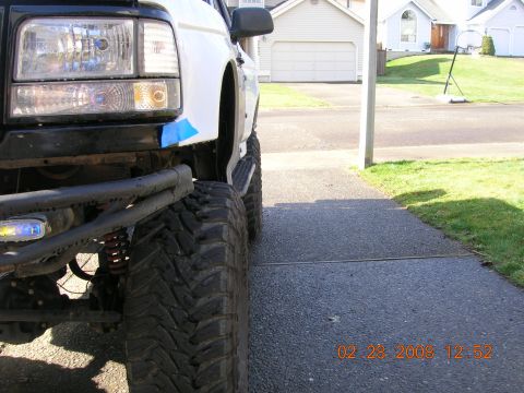 1996 Ford Bronco - The front passenger side of a lifted Ford Bronco is shown parked in a driveway.