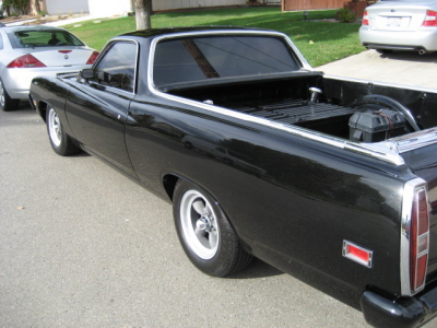1970 Ford Ranchero - A black 1970 Ford Ranchero pickup truck is parked on a street, with another car behind it.