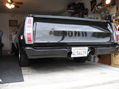 1970 Ford Ranchero - The rear of a black 1970 Ford Ranchero is visible, dual exhaust pipes and a California license plate.