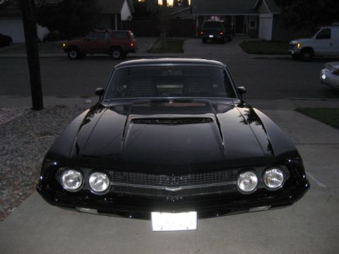 1970 Ford Ranchero - A black coupe with a prominent hood scoop is parked in a suburban driveway at dusk.