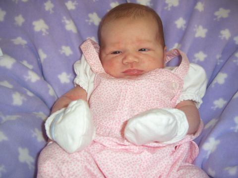 1987 Suzuki Samurai - A newborn baby is dressed in pink overalls and white mittens, resting on a soft purple blanket adorned with white star patterns.
