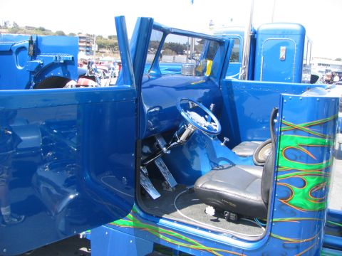 1986 Pontiac Fiero - Custom blue semi-truck interior a chrome steering wheel and a flame-painted exterior panel.