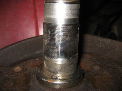 1991 Ford Bronco - Worn wheel bearing spindle showing significant scoring and wear marks.