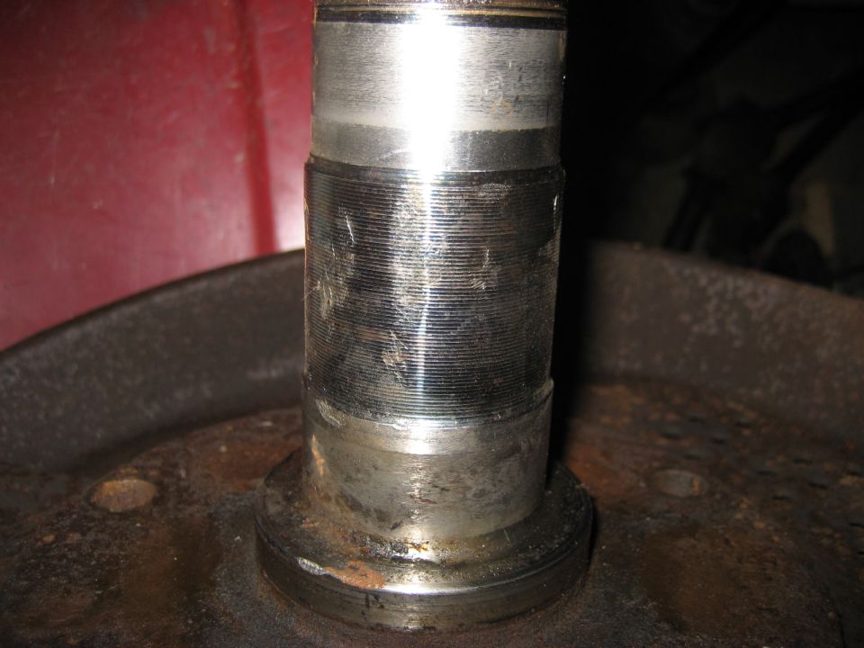 Close-up of a worn wheel bearing spindle with visible scoring