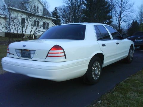 2003 Ford Crown Victoria - The rear of a white 2003 Ford Crown Victoria is shown parked in a driveway.