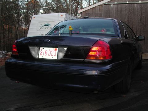 1999 Ford Crown Victoria - Rear view of a dark 1998 Ford Crown Victoria, showing its distinctive taillights and license plate.