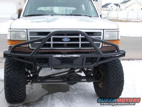 1996 Ford Bronco - Head-on view of a white lifted 1990s Ford truck/SUV wearing a black tubular front bumper with a center pre-runner hoop and full-width tube…