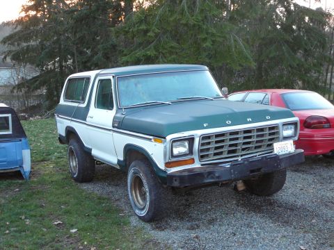 1978 Ford Bronco - This two-tone green and white 1978 Ford Bronco is parked outdoors next to a red sedan and a blue truck bed.