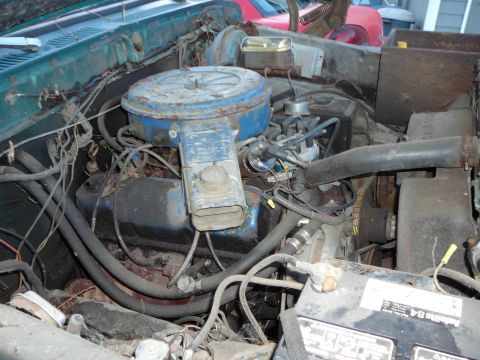1978 Ford Bronco - The engine bay of a vehicle, showing the air filter housing, distributor, and battery.