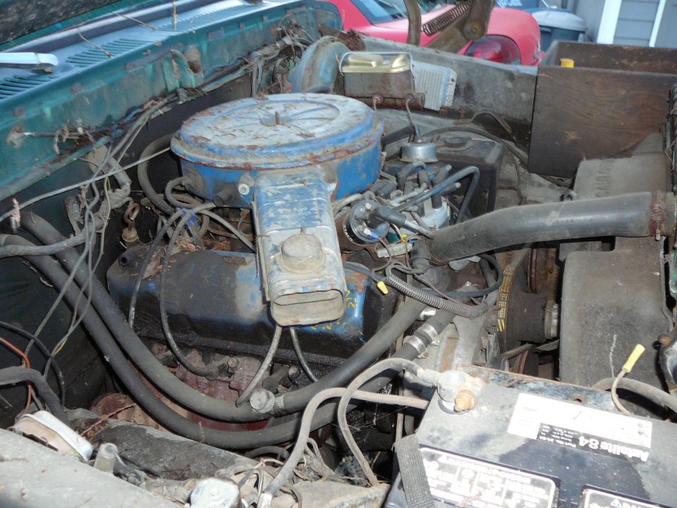 Engine bay with blue air cleaner and various hoses and wires