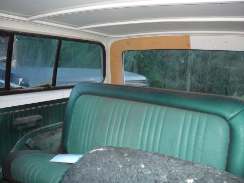 1978 Ford Bronco - The interior of a vehicle shows green seats and dark paneling, with another vehicle visible outside.