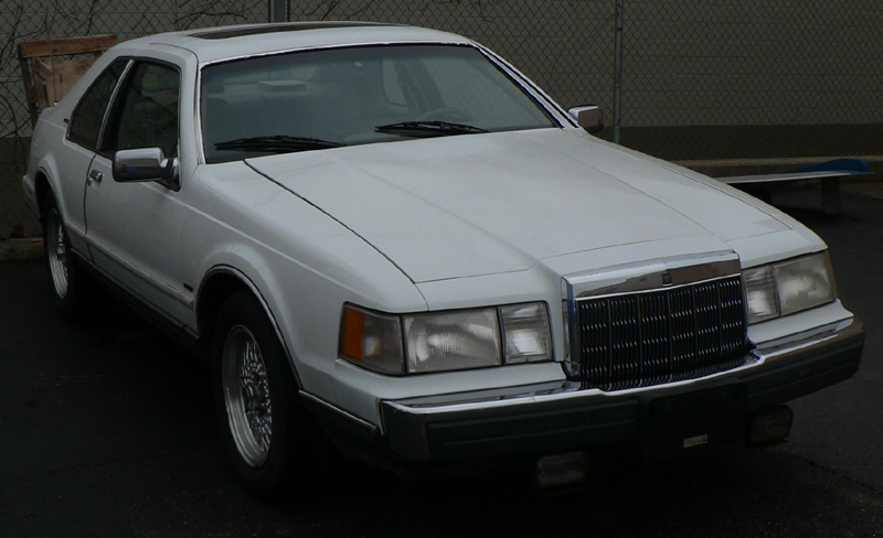 White Lincoln Mark VII coupe, three-quarter front view, chrome grille, wire wheels