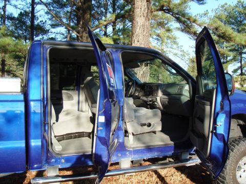 2003 Ford F-250 - Interior view of a blue pickup truck with all doors open, revealing the seating and dashboard area.